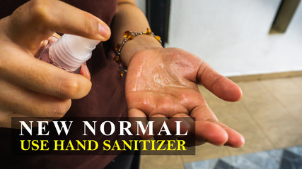 Woman spraying hand sanitizer alcohol liquid using the bottle sprayer and applied to her hand before going out from house. New normal or changing lifestyle concept after Coronavirus outbreak.