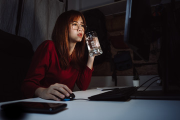 Korean woman working late time with laptop computer drinking water home office workhard overworked, Freelancer stay home business quarantine sleepless crisis coronavirus stay home dark room...