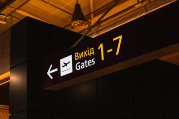 Exit sign to the gate on a yellow board at the Ukrainian airport