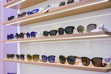 Storefront shelves of various modern sunglasses at the airport's retail store