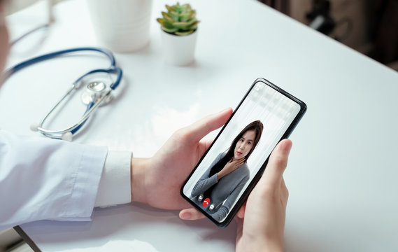 Asian doctor video conference with woman patient care discussing and consultant for medical coronavirus video call user interface healthcare online service remotely talking when quarantine at home.
