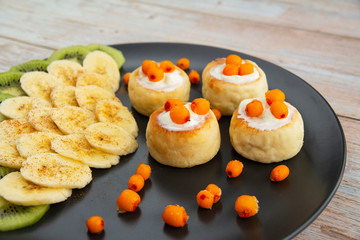 Sour cream cheesecakes with bananas, kiwi and sea buckthorn