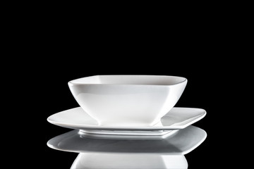 White round plate for food on dark background. Empty dishes for dinner isolated on black. Restaurant kitchen minimalistic concept.