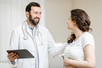 Doctor with pregnant woman during a medical consultation in gynecological office. Concept of medical care and health during a pregnancy