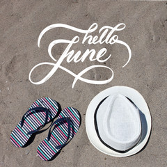 Fototapeta na wymiar Hello June hand lettering card. Hand drawn script and sand on the beach on background. Seasons calendar months.
