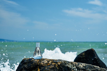 Glass bulb. Sea shore. Waves hit the stones.