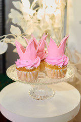 Pink vanilla cupcakes on glass stand, copy space. Dessert table for party. Holiday concept. Candy bar