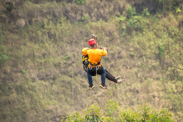 Man and Woman enjoying zipline adventure with take photo at Tad Fan waterfall in Laos