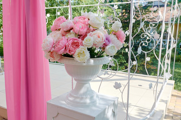 Bouquet of white and pink flowers in vintage vase on table outdoors, free space. Wedding floral decoration. Beautiful set up for wedding ceremony
