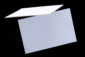 White 3-ply business cards, floating on a black background, a mock-up