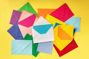 C6 envelopes of various colors, shot from the top on a yellow background