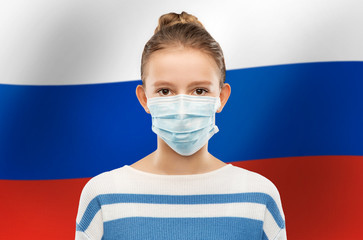 health protection, safety and pandemic concept - teenage girl in protective medical mask over flag...