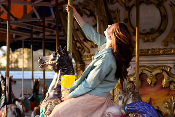 girl riding a carousel in a park