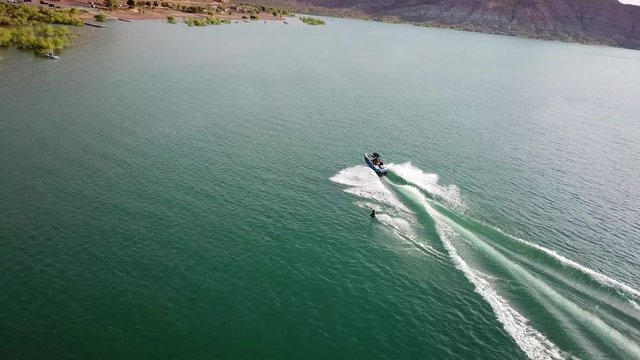 Waterskiing in Quail Creek State Park Recreational Area. Cinematic Aerial View of Speedboat asd Skier