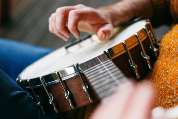 Close up of a male banjo player relaxing on the porch, practicing clawhammer, finger picking and thumb tapping. He's playing some great country and western classic songs!  
