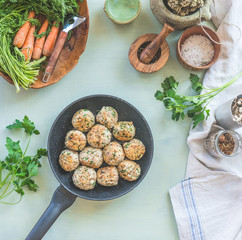 Delicious fried buckwheat balls in frying pan on kitchen table background with seasonings and herbs. View from above. Concept of healthy homemade vegan food. Home cuisine