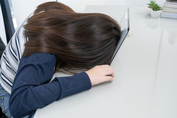 Young woman long hair fall asleep on desk with laptop