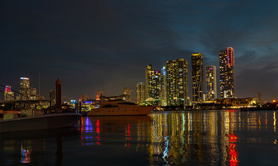 Fototapeta premium Miami city skyline panorama at dusk with urban skyscrapers and bridge over sea. Miami downtown view at night.