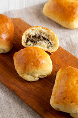 Home-baked Beef Russian Bierocks on a rustic wooden board on a white wooden background, low angle view. Close-up.