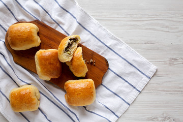 Home-baked Beef Russian Bierocks on a rustic wooden board on a white wooden table, top view. Flat lay, overhead, from above. Copy space.