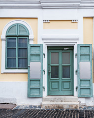 Old wooden door close-up on a background of a wall .