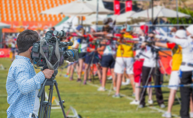 Cameraman shooting live broadcast from sport game to television and internet on the background blured Unidentified sportsman 