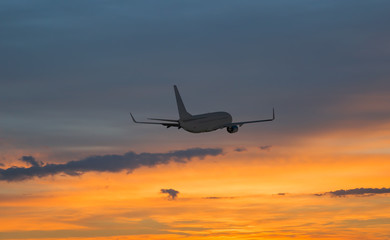 Obraz premium Airplane flying above tropical sea at sunset
