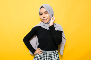 Asian woman smiling wearing hijab on yellow background