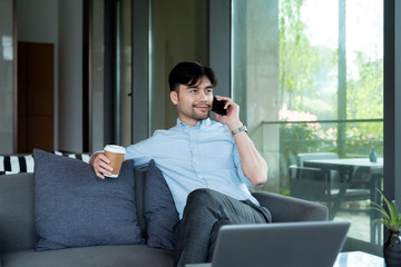 Asian business male using laptop  in the indoors