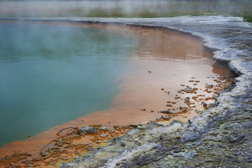 Geothermal lake with an orange shoreline