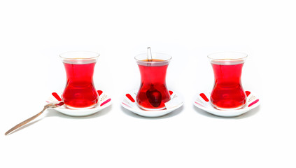 Three glass of turkish tea isolated on white background - the cup of tea in the back is blurred