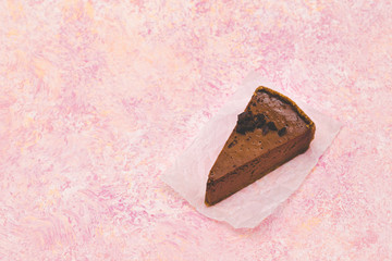 slice of chocolate cheesecake on a pink grunge background