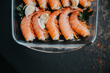 Food background with seafood. Lots of copy space. fresh shrimps served on a wood plate with garlic
