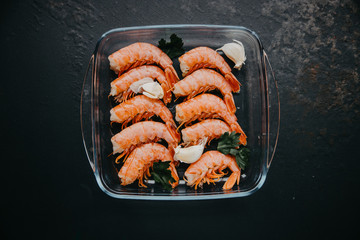 Prawns on plate. Shrimps, prawns. Seafood. Top view. Dark background. 