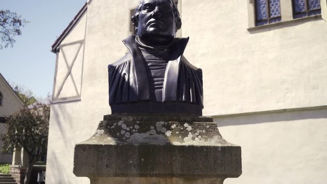 Cinematic lift up to reveal Martin Luther bust in Wittenberg, Germany. The protestant reformer who nailed his thesis to the castle church door.