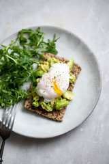 Tasty sandwich with poached egg and avocado on mrble background with copy space