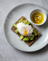 Tasty sandwich with poached egg and avocado on mrble background with copy space
