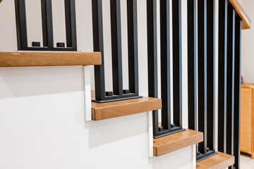 Metal handrails and wooden stairs. Combination of types of materials. Black brushed metal. Loft and high-tech