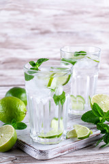 Mojito cocktail with ice, mint and lime on white background