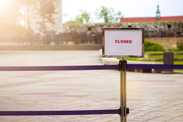 Fence and sign Closed in Sunny weather on territory of old city. Road ahead closed sign with red letters.