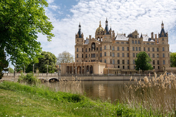Fototapeta na wymiar Schwerin Castle or Schwerin palace, in German Schweriner Schloss, a famous landmark building on a lake in the capital city of Mecklenburg