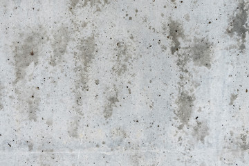 Old gray concrete wall with wet spots.