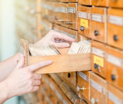 Close Up Student's Hands Search From A Filing Cabinet In The Library