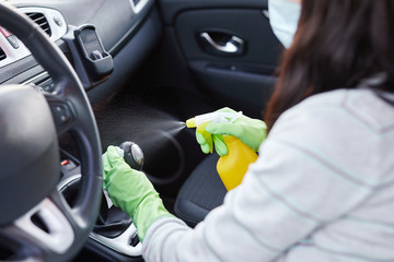 Female hand spraying sanitizer and antiseptic wet wipes for disinfecting car. Cleanliness and healthcare during Corona virus, COVID-19.