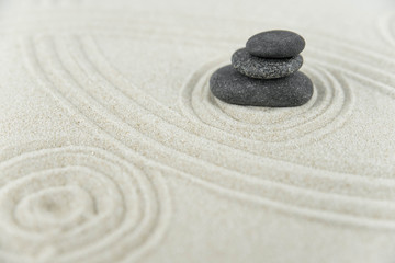 Fototapeta premium Zen garden. Pyramids of white and gray zen stones on the white sand with abstract wave drawings. Concept of harmony, balance and meditation, spa, massage, relax.