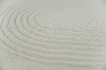 Abstract Zen drawing on white sand. Concept of harmony, balance and meditation, spa, massage, relax. Zen garden.