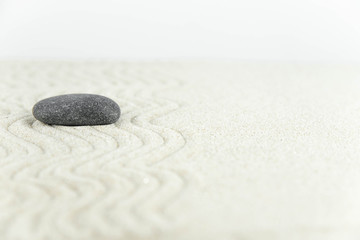 Fototapeta premium Ogród zen. Piramidy z białych i szarych kamieni zen na białym piasku z abstrakcyjnymi rysunkami fal. Pojęcie harmonii, równowagi i medytacji, spa, masaż, relaks.