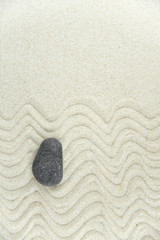 Zen garden. Pyramids of white and gray zen stones on the white sand with abstract wave drawings. Concept of harmony, balance and meditation, spa, massage, relax.