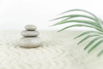 Foto op Plexiglas Zentuin. Piramides van witte en grijze zenstenen op het witte zand met abstracte golftekeningen. Concept van harmonie, balans en meditatie, spa, massage, ontspannen. © strigana