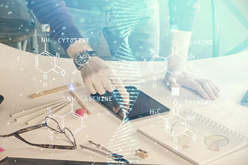 Double exposure of man's hands holding and using a phone and DNA drawing. Medical education concept.